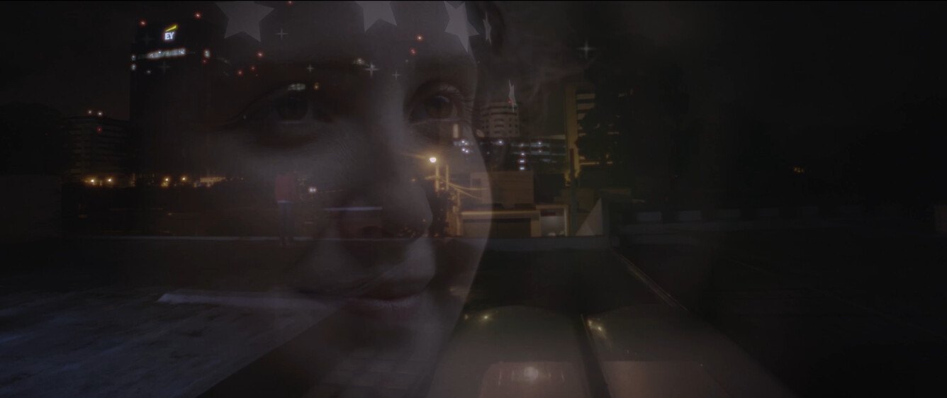 Still from Hidden Treasure of the Sweet Absolute: a woman's face, framed by stars, fades over a city at night.